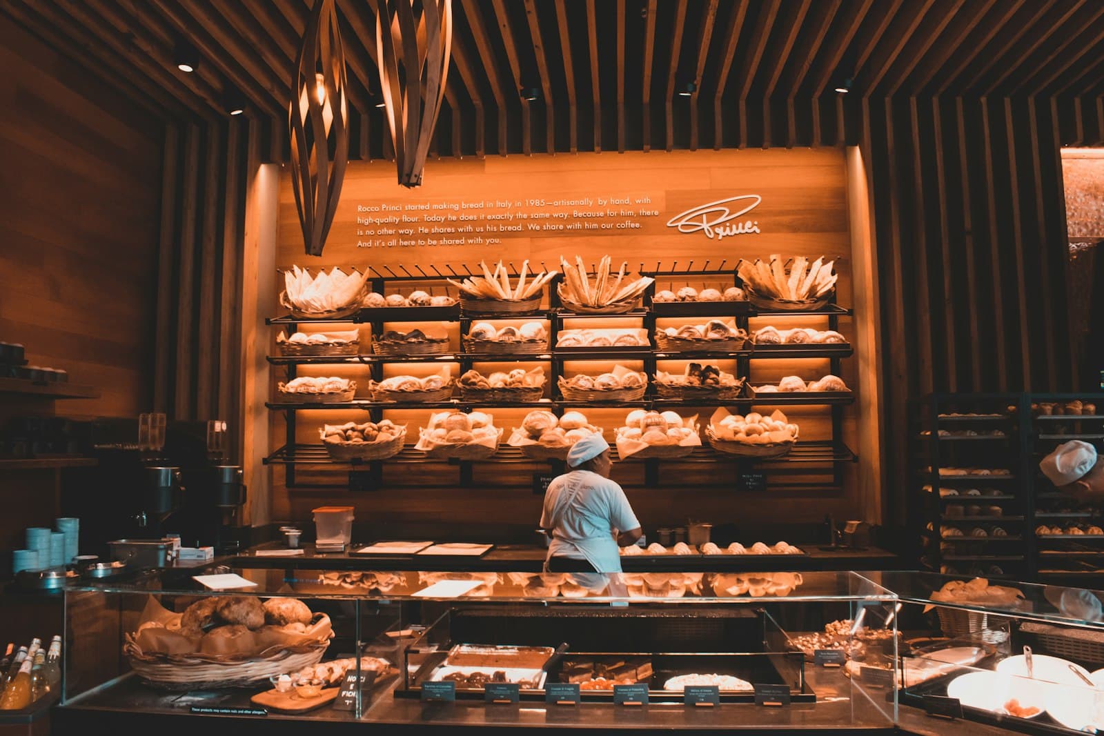 Un commerçant devant les rayons de sa boulangerie