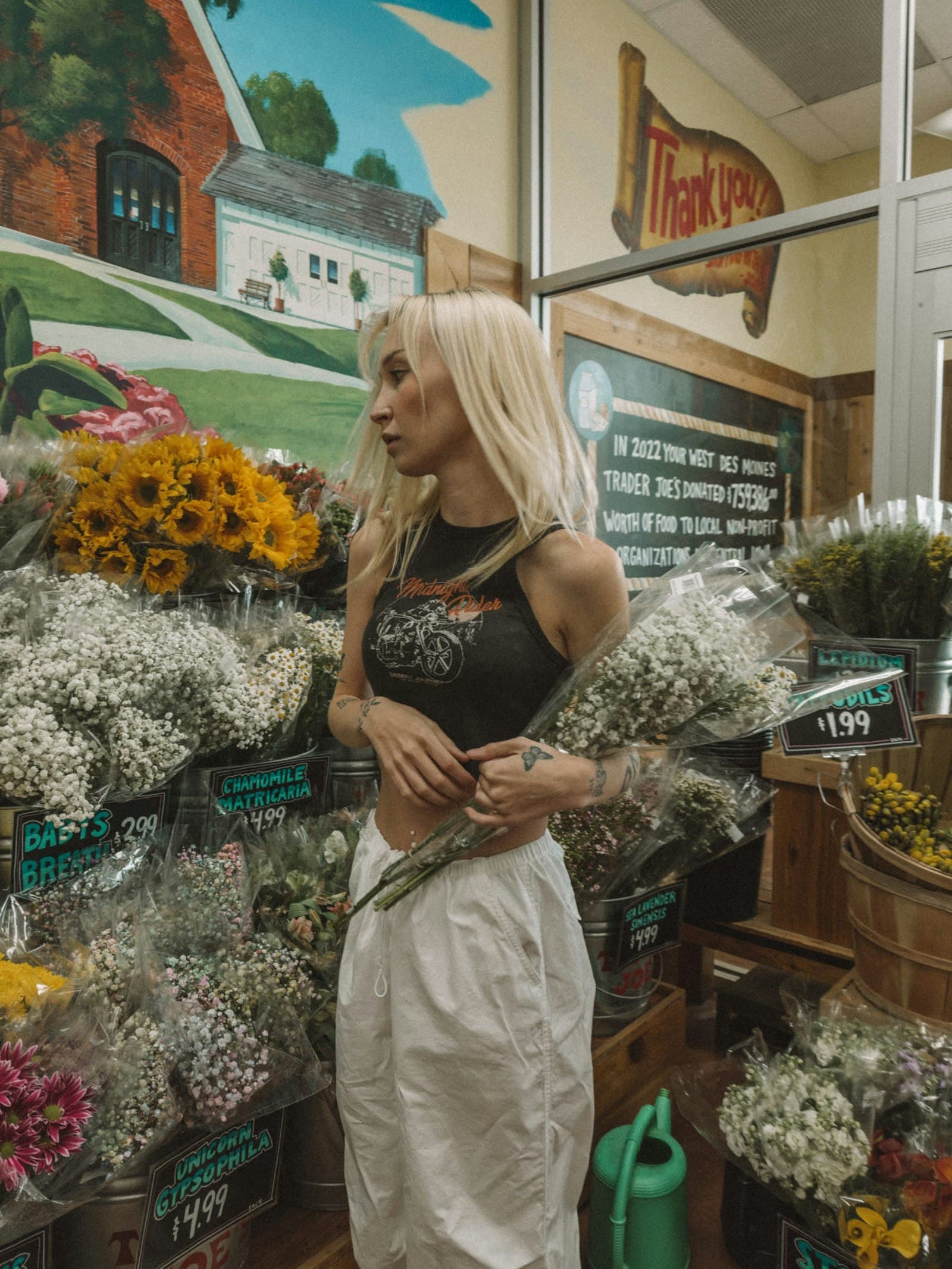 Une commerçante devant sa boutique de fleurs