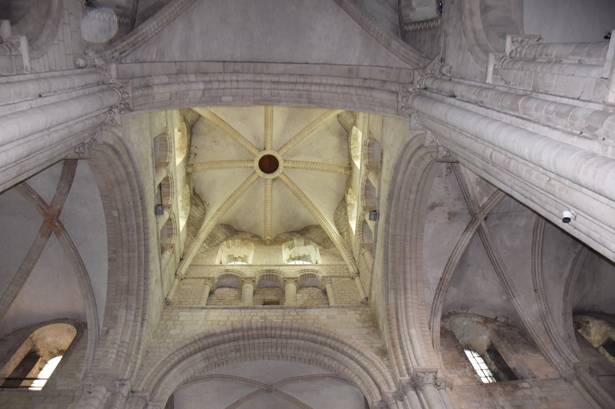 La voûte de pierre nervurée d'une nef d'abbaye romane.