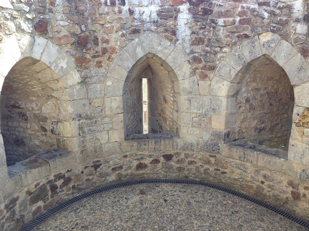 Les baies en arc brisé d'une salle de château médiéval en pierre.